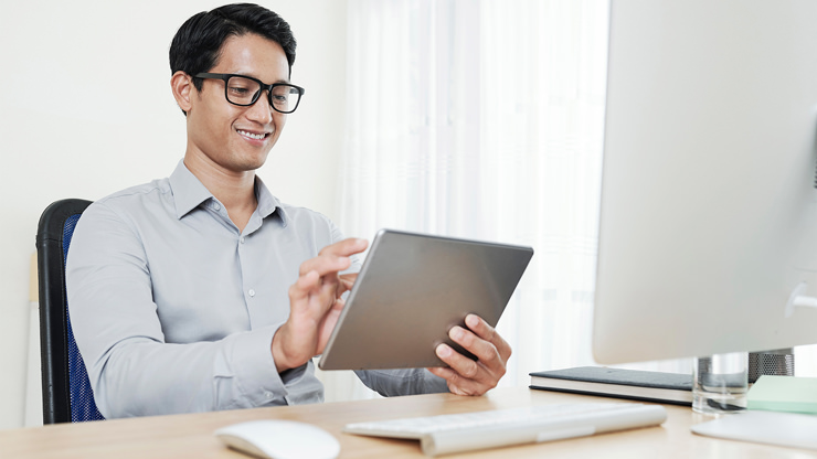 man filling out application on tablet