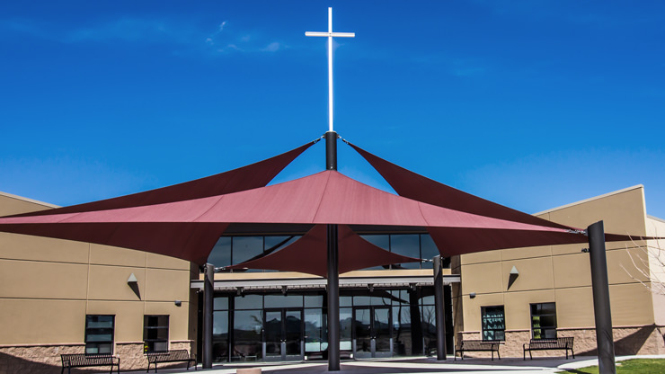 beige church with red roof and white cross on roof