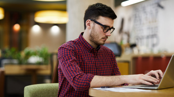 young man working on laptop at desk