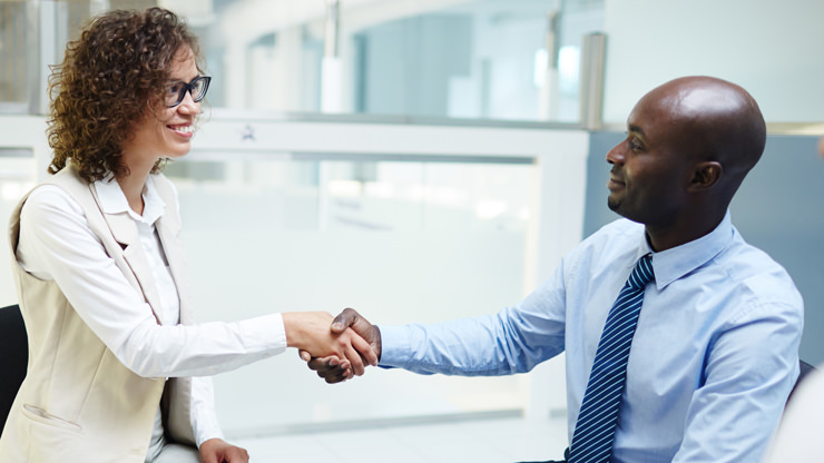 young man shaking hands with young woman