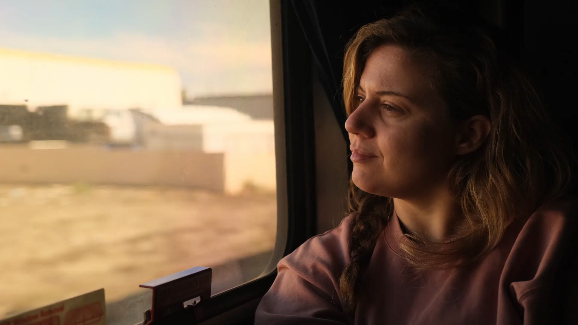 young woman on train looking out window