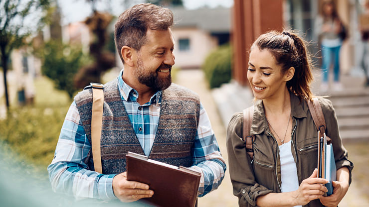 male student talking with young girl while walking